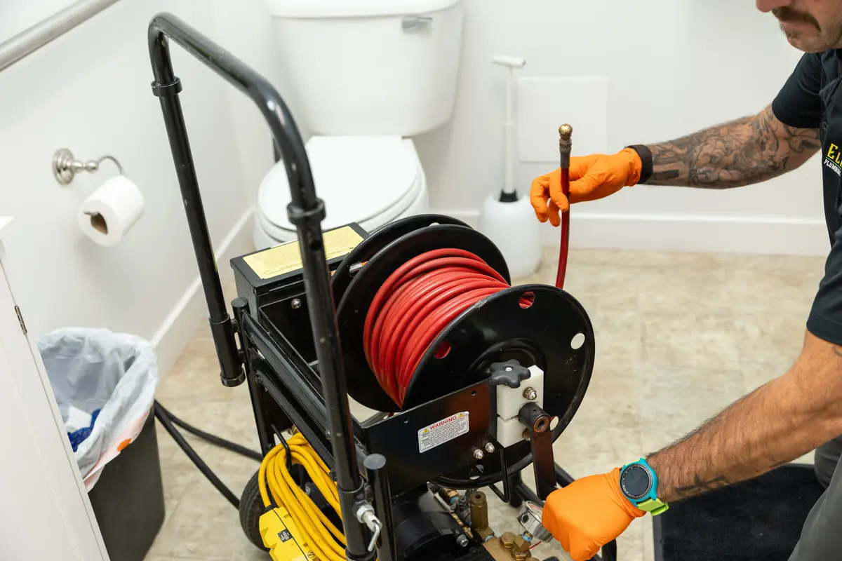 Element plumber clearing a restroom drain beside a toilet in St. George, UT