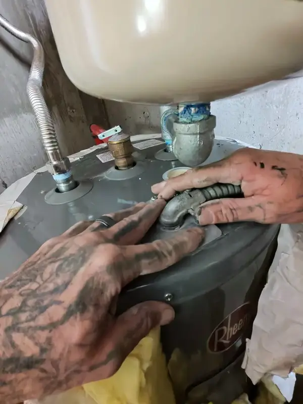 Element plumber fixing a leaking water heater fitting in St. George, UT
