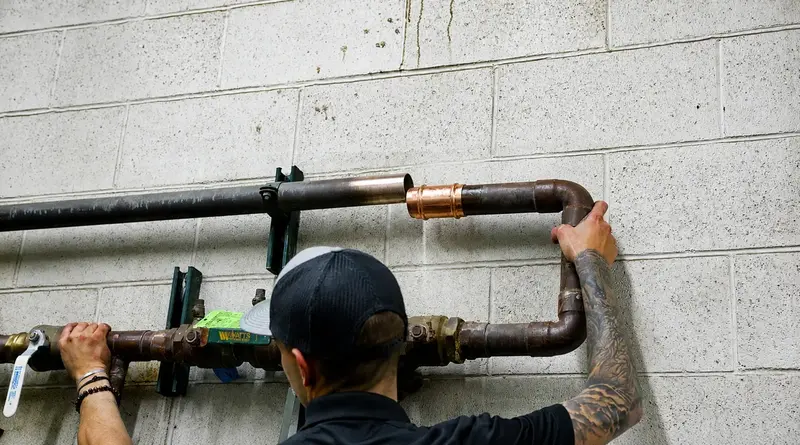 Element plumber routing copper water line in St. George, UT