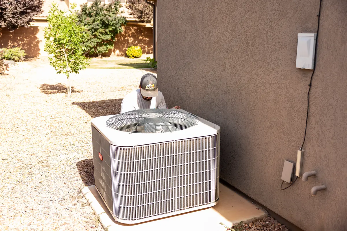 Outdoor AC condenser beside a stucco home in St. George, UT