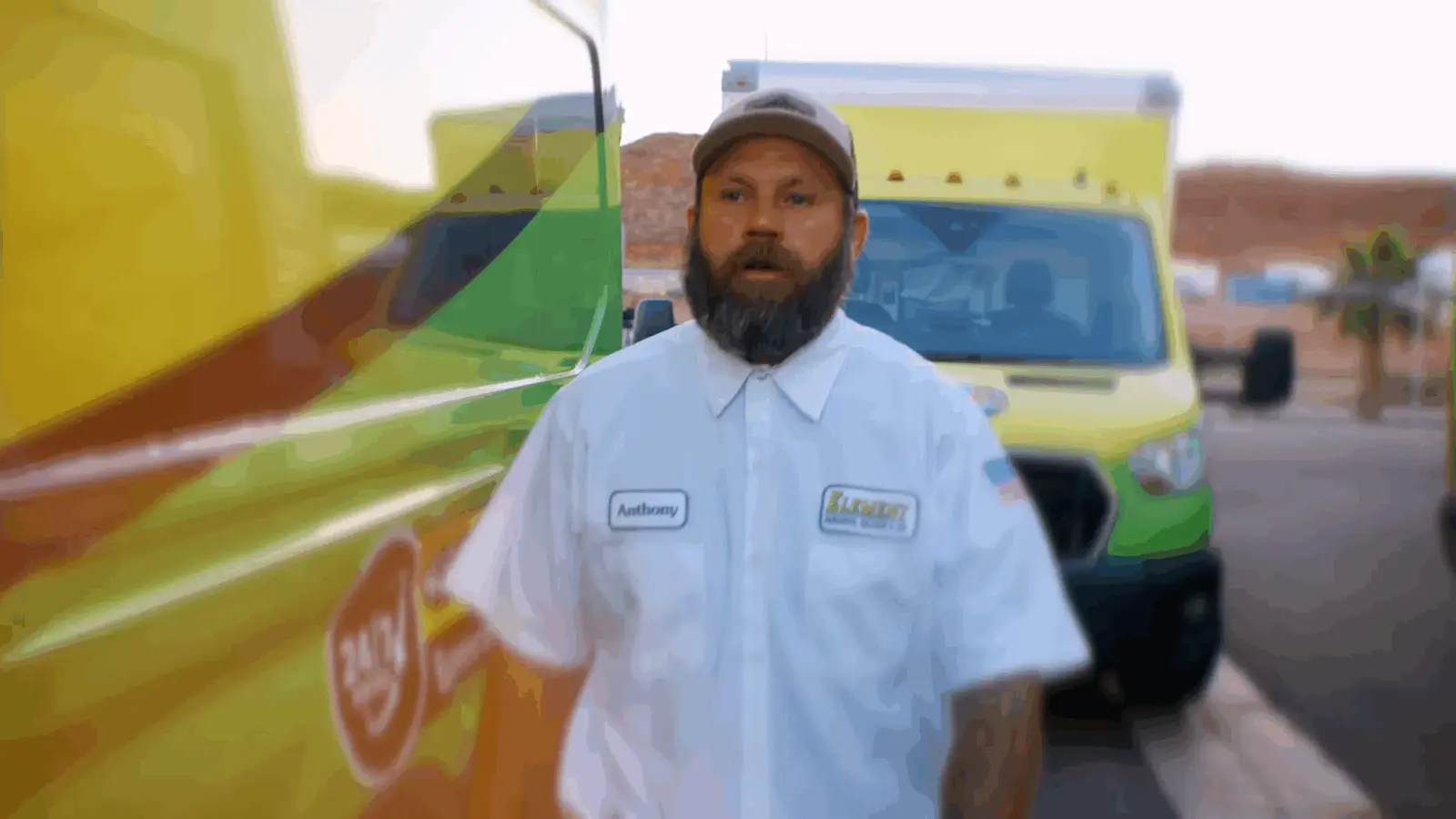Element drain cleaning technician standing beside service trucks in St. George, UT