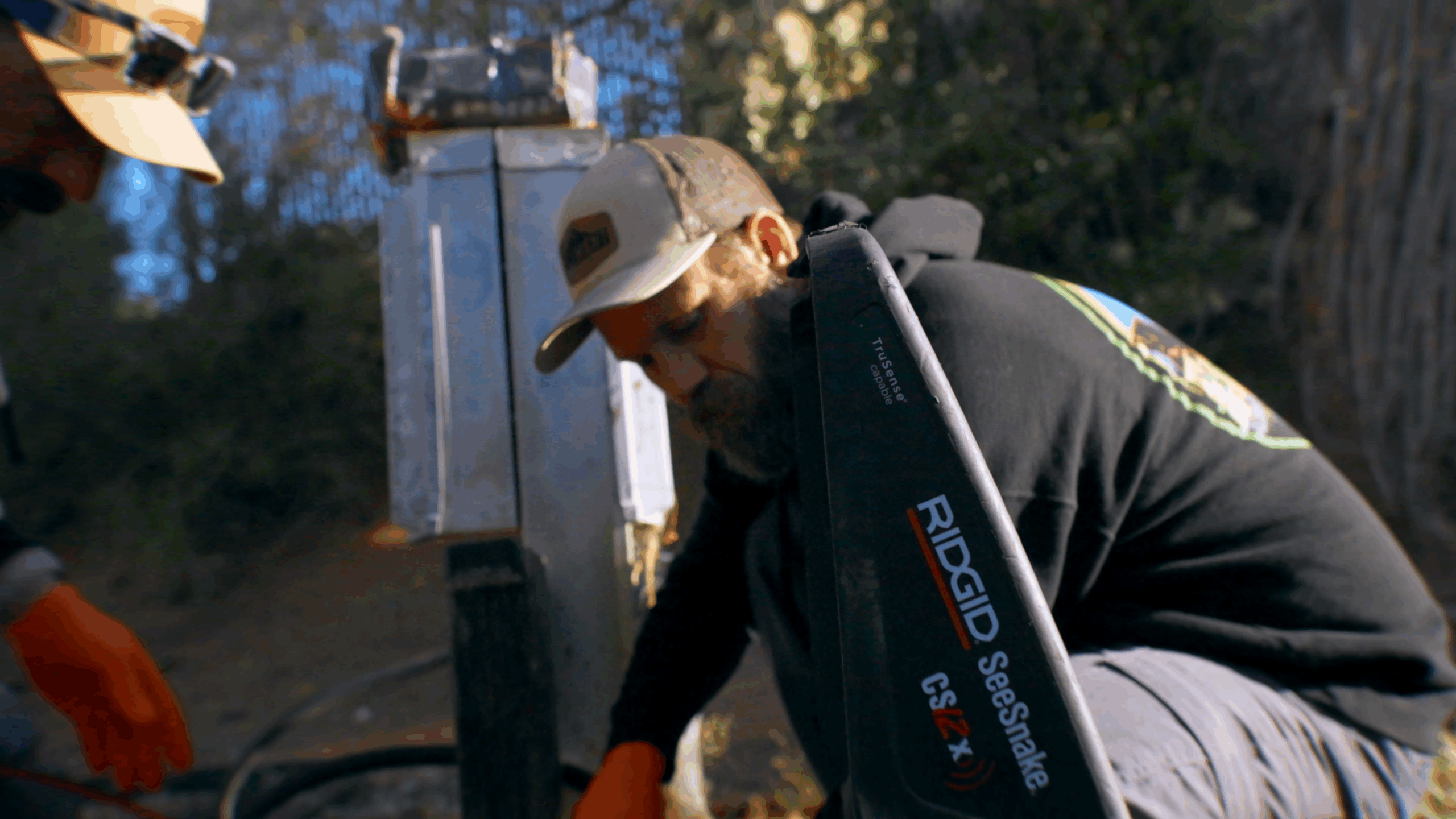 Element St. George plumber working with a RIDGID SeeSnake CSx VERSA inspection camera near a utility box during outdoor leak detection and repair service in St. George, UT.